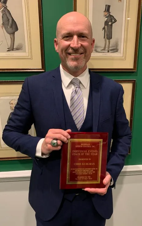 Chris Kuhlman holding his Coach of the Year plaque