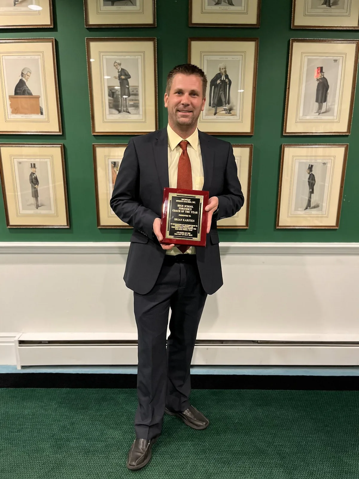 Brian Karsten holding his Coach of the Year plaque