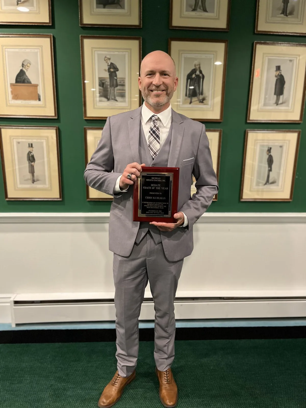 Chris Kuhlman holding his Coach of the Year plaque