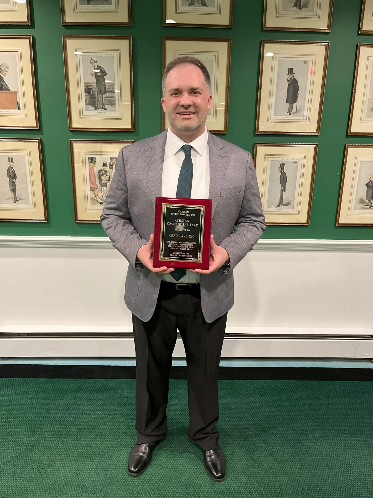 Chris Pavlicko holding his Coach of the Year plaque