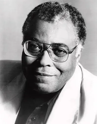 Black and white publicity portrait of James Earl Jones in glasses and a light jacket