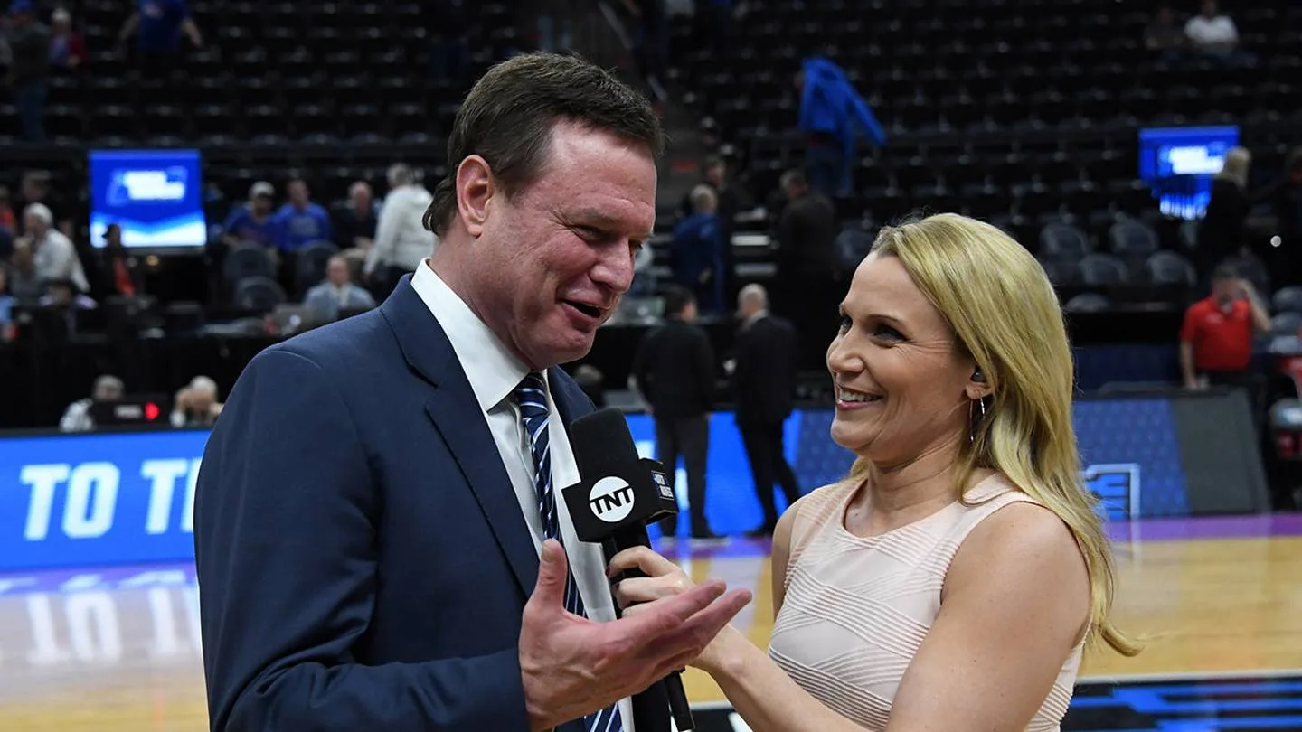 Lisa Byington interviewing a man in a suit on a basketball court, holding a TNT microphone