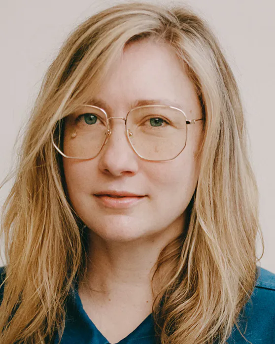 Liz Meriwether smiling in a portrait, wearing glasses
