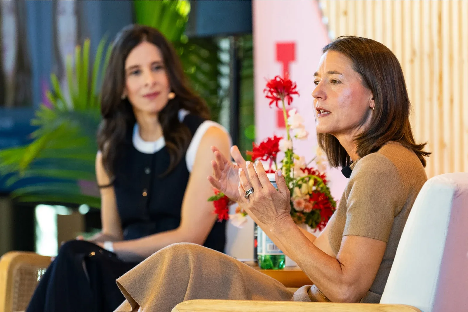 Mary Ellen Coe gesturing while speaking during a fireside chat on stage