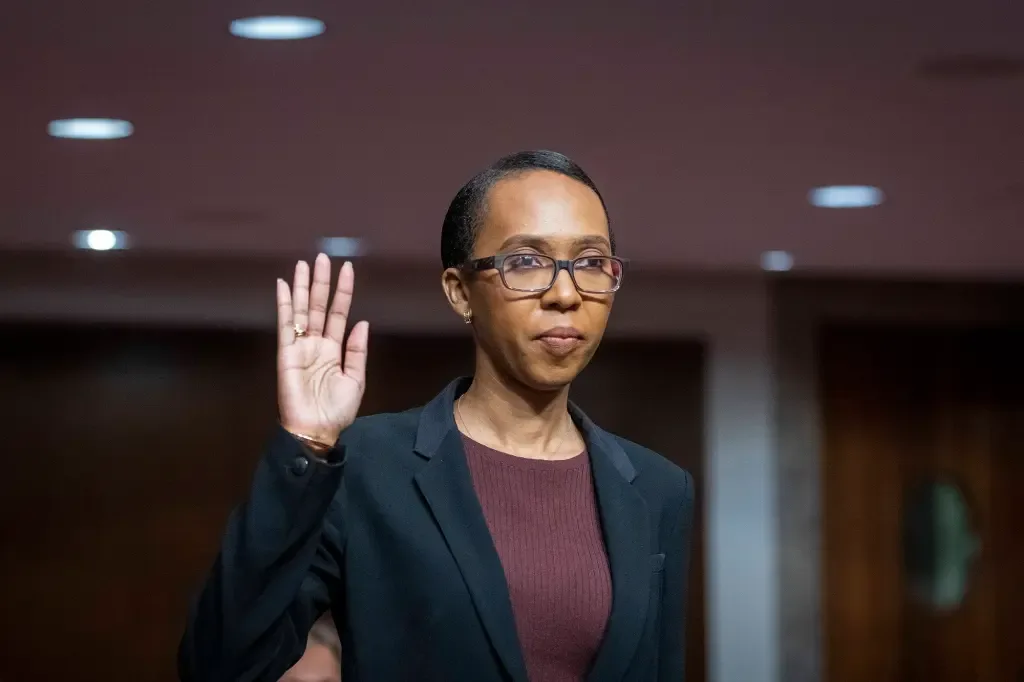 Tiffany P. Cunningham raising her right hand while standing in a wood-panelled hearing room