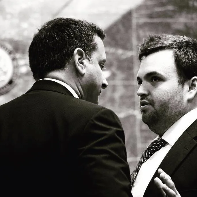 Black and white photograph of Wade Fink, right, in conversation with another man in a suit